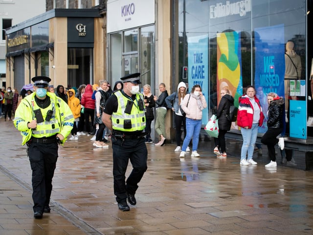 Police patrol alongside the queue outside the Primark store.