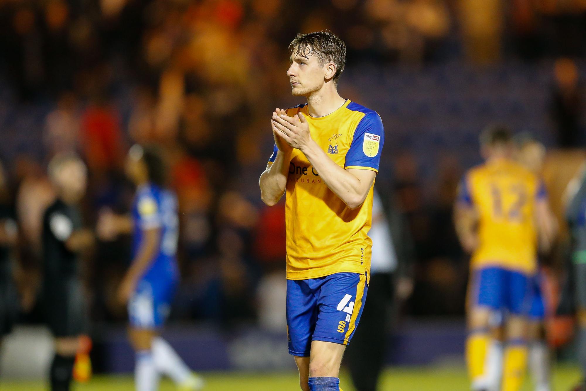 Goalscorer Elliott Hewitt applauds the travelling Mansfield fans