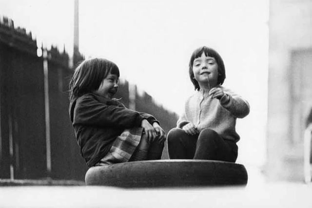Two friends share a laugh in an Edinburgh street, 1966.