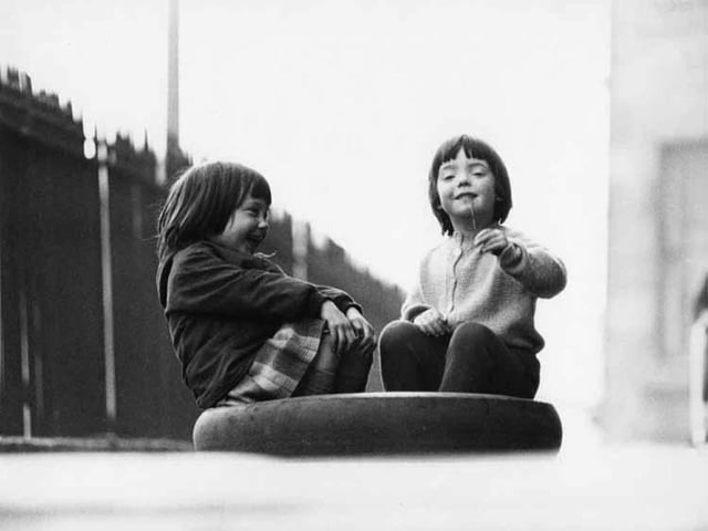 Two friends share a laugh in an Edinburgh street, 1966.