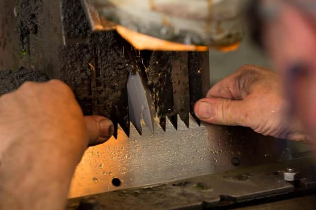 Traditional hand grinding of a toothed knife - most of this work is now done on CNC machines at Fernite.