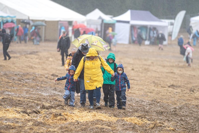 A family wade through the drenched mud at Wickham Festival on day one. Picture: Andy Hornby