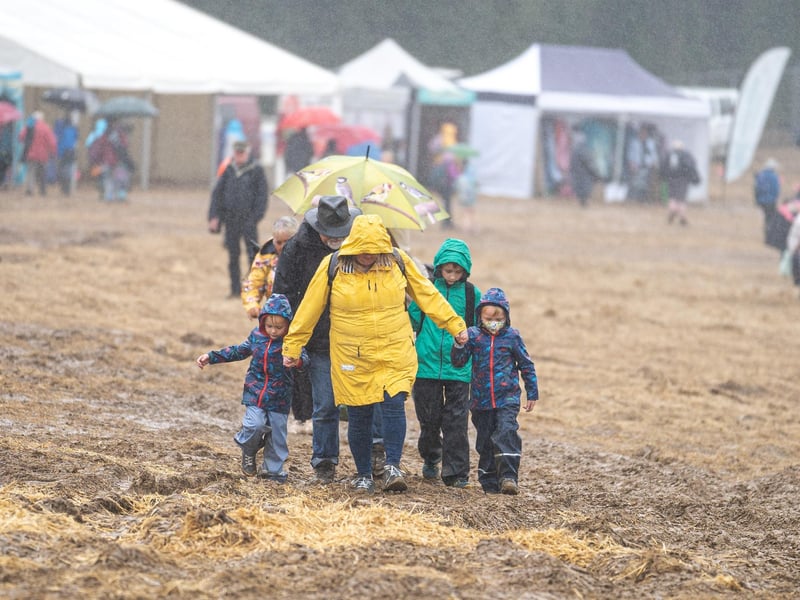 A family wade through the drenched mud at Wickham Festival on day one. Picture: Andy Hornby