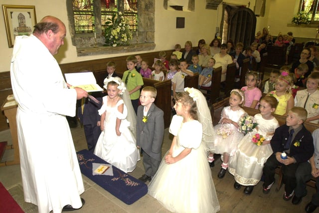 Pictured at Armthorpe Church, Armthorpe, Doncaster,  in 2001 where vicar  Richard Landall  conducted a double mock wedding with local children taking part. Seen is the vicar with Brides and Grooms LtoR,  Bride  Robyn Thorpe, and groom Jacob Betts, Bride Amy Hood, and groom Joe Alderson.