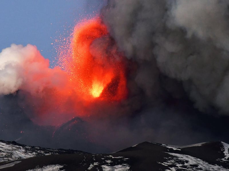 This photo obtained from Italian news agency ANSA shows the Etna volcano in Catania, Sicily, on February 16, 2021 during a spectacular eruption and a strong explosive activity from the south-east crater and the emission of a high cloud of lava ash that disperses towards the south.