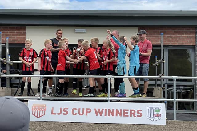 Sheffield United skipper Billy Sharp's son Leo, centre, gets his hands on the LJS Cup