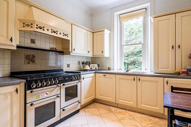 The kitchen has a range of painted wood units with contrasting worktops and integrated appliances which include a fridge freezer, dishwasher, washing machine and a gas/electric range cooker.