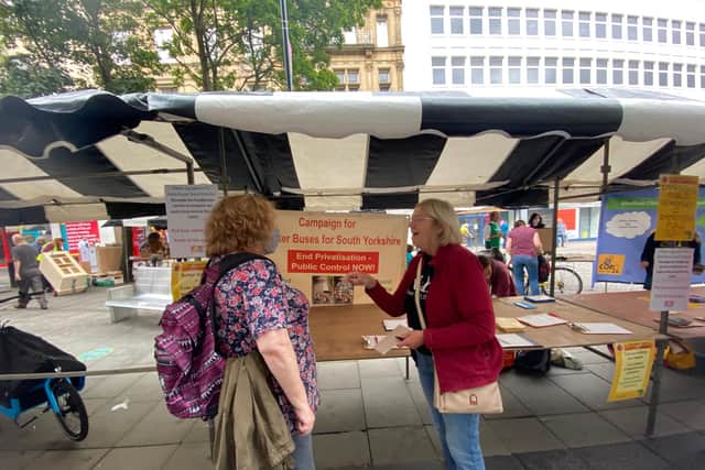 Campaigner Fran Postlethwaite, right, talks to a member of the public about bus services.