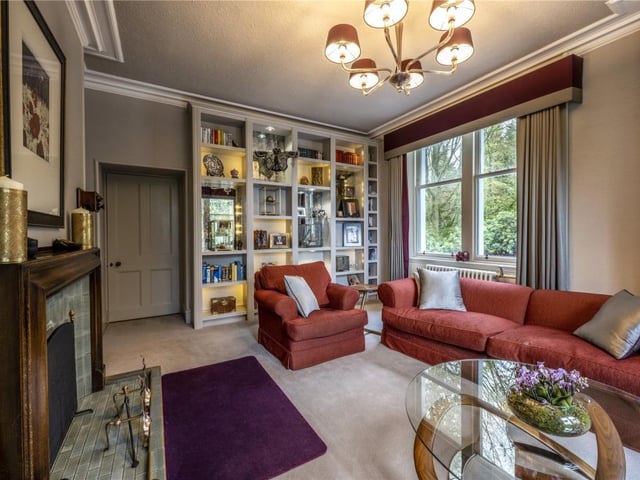 The corner aspect sitting room has an open fireplace and twin aspect windows.