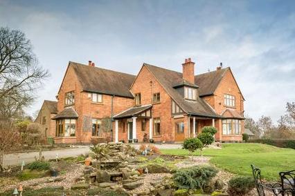 This beautiful, seven-bedroom, detached country mansion with beautiful open views sites in the acres, with gardens, a paddock, stables and menage.