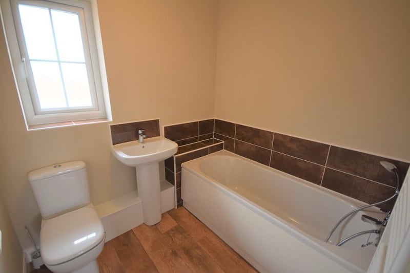 Bathroom - A contemporary three piece bathroom suite having a panelled bath with chrome shower hose, low flush wc, wash hand basin with chrome mixer tap and co-ordinating tiled splashback, wall mounted towel rail, extractor fan and double glazed obscure window.