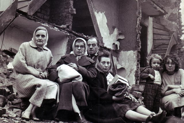 Families sitting in the ruins of their homes, ripped apart by the Sheffield hurricane of February 16, 1962. Hundreds of Sheffielders were left homeless