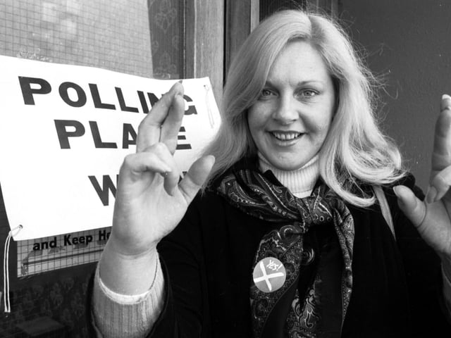 SNP politician Margo MacDonald keeps her fingers crossed at a polling station in Glasgow during the referendum vote on Scottish devolution in March 1979.