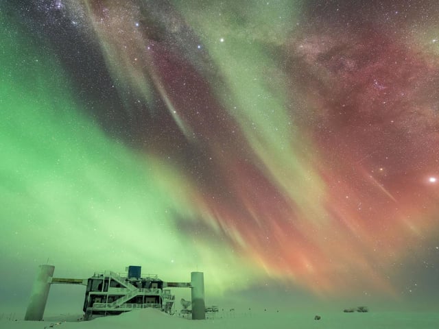 This image shows a strong and colorful aurora over the IceCube Neutrino observatory in the South Pole.