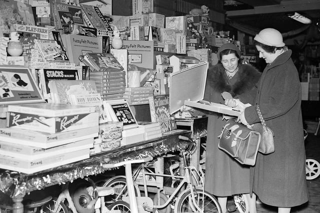 Two women inspect a weaving compendium while Christmas shopping at Thorntons on Princes Street in 1958.