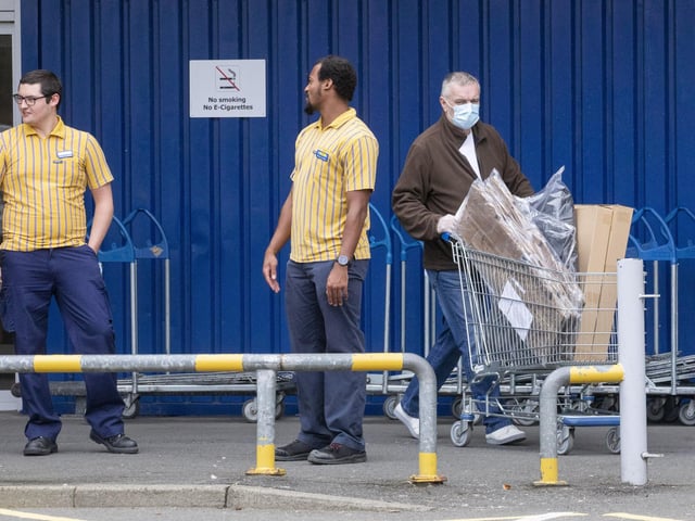 Metal barriers and yellow dots showed people where to queue while maintaining social distancing, and some shoppers wore face masks in preparation for browsing.