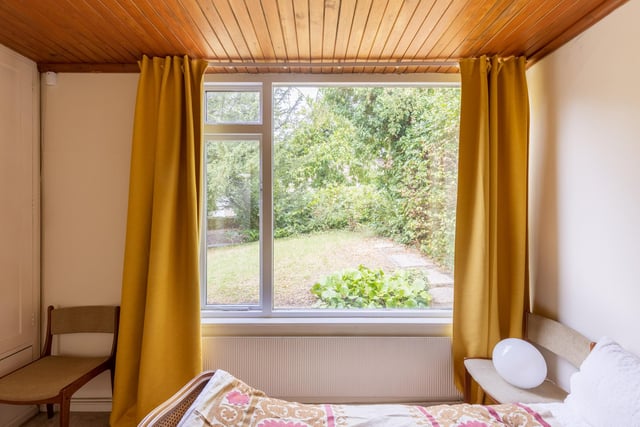 This bedroom offers a lovely view of the garden.