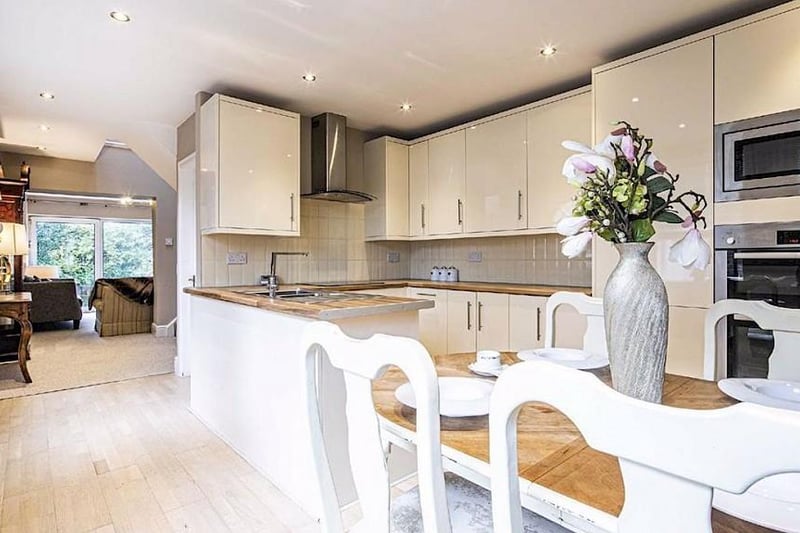 The kitchen diner has a range of high gloss fitted units with contrasting worktops and integrated appliances including a fridge, freezer, double oven, induction hob, microwave and a slimline dishwasher.