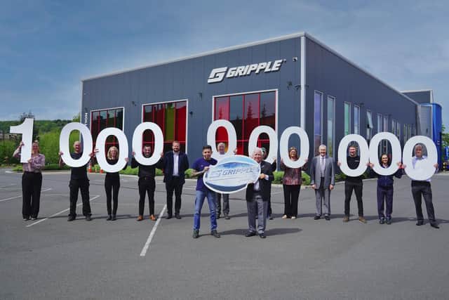 Gripple chairman Hugh Facey (right centre), global managing director Ed Stubbs, UK managing director Kevin St Clair, and operations director Charlotte Hill, with current and former employees celebrating the company’s one billionth fastener outside the company’s Riverside Works factory in Sheffield.