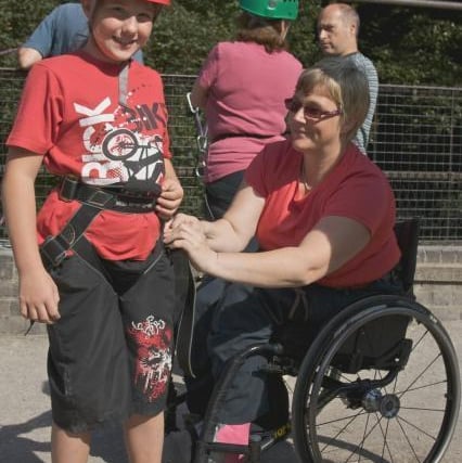 Wheelchair sportswoman Kathy Hancock gets Georgia Duckworth, 9, ready for her abseil at Millers Dale in Derbyshire back in 2009