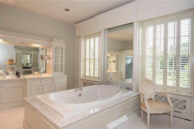 The property boasts six bathrooms throughout, including this large, beautifully decorated suite, with a dressing area and large bath tub at its heart.