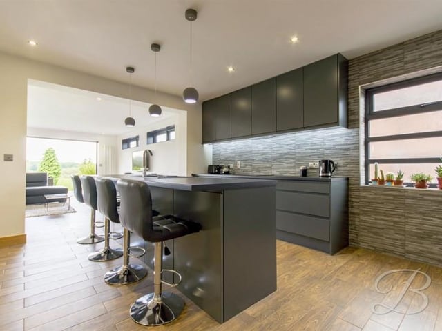 Finished to an extremely high standard, with a range of matching and modern wall and base units, having an electric hob with an extractor over and a built in double electric oven and microwave.