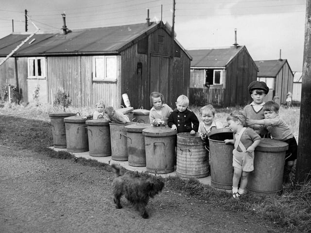 Sighthill Camp Edinburgh Children playing at the line of rubbish bins, 1954.