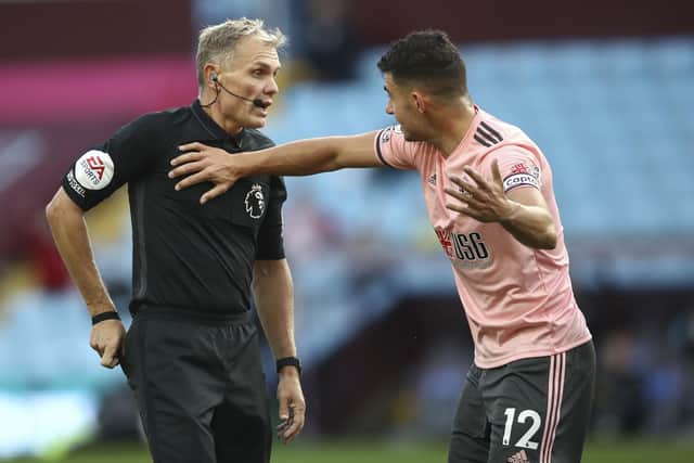 Sheffield United's John Egan gesturers after receiving a red card during the English Premier League soccer match between Aston Villa and Sheffield United at the Villa Park stadium in Birmingham, Monday, Sept. 21, 2020. (Tim Goode/Pool via AP)