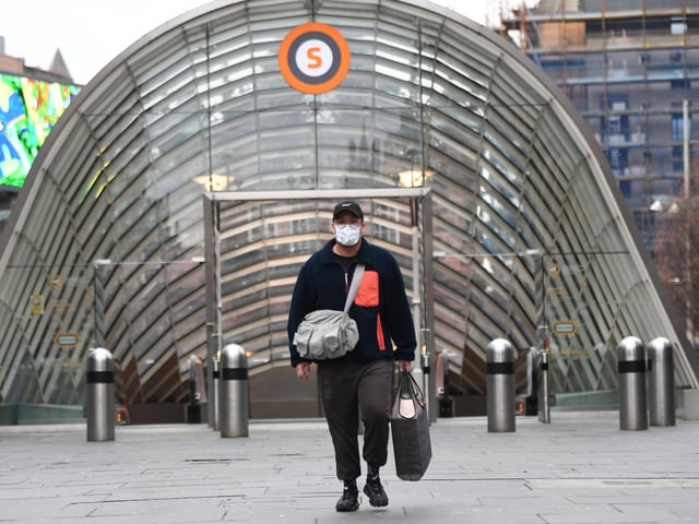 A person seen walking through Glasgow with a mask on as coronavirus-related deaths continue to rise across the country.