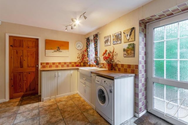 A utility room always comes in useful. This one includes traditional cabinets, units and work surfaces, a Belfast sink, space and plumbing for a washing machine, and a cupboard for additional storage.