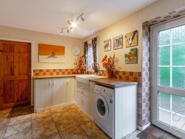 A utility room always comes in useful. This one includes traditional cabinets, units and work surfaces, a Belfast sink, space and plumbing for a washing machine, and a cupboard for additional storage.
