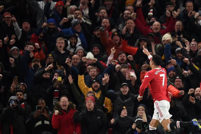 Cristiano Ronaldo celebrates in front of supporters after scoring their second goal, his 800th for club and country in his career during the English Premier League football match between Manchester United and Arsenal at Old Trafford in Manchester, north west England, on December 2, 2021. (Photo by OLI SCARFF/AFP via Getty Images)