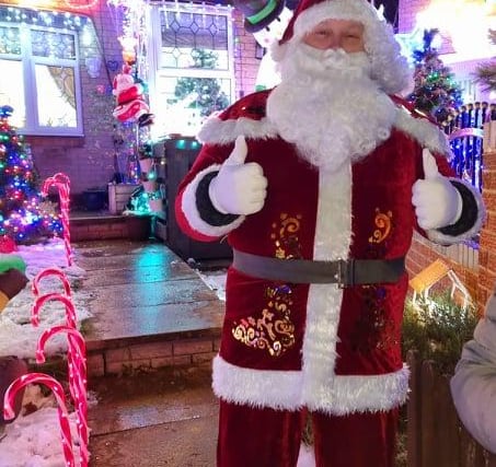 Andrew Green as Santa in front of the amazing Christmas lights display on Lyons Street in Pitsmoor, Sheffield, which was created to raise money for The Sick Children's Trust