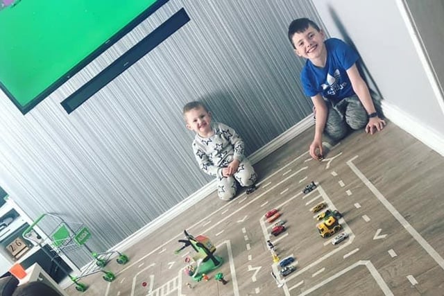 Charlie, three, and Alfie, eight, with their homemade car track.