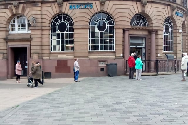 Shoppers take their place in a queue for Barclays bank in South Shields.