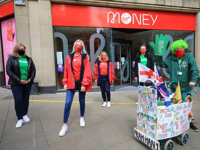 John Burkhill took his first walk around Sheffield today with the help of staff from Virgin Money on Fargate. Picture: Chris Etchells