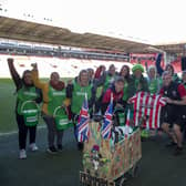 John Burkhill at Sheffield United's Bramall Lane ground with the Blades shirt he's auctioning to raise money for Macmillan Cancer Support