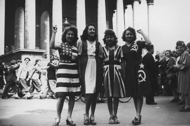 A group of women wearing dresses representing flags of the Allied powers in Paris on VE Day, May 8, 1945