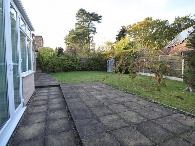 Another view of the patio area, which sits in a private setting thanks to the hedgerows, shrubs and trees.
