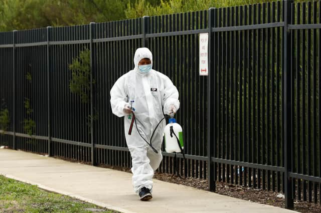 A cleaner in protective gear with specialist equipment. Picture: Darrian Traynor/Getty Images.
