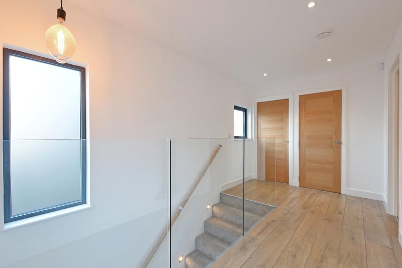 The entrance hall has a side facing aluminium double glazed obscured window, recessed lighting, pendant light point, a designer central heating radiator and tiled flooring. Oak doors open to the master bedroom, bedroom five and storage cupboard.