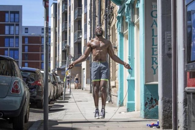 Obi Johnson exercises in the good weather in the street outside his home in Edinburgh. Photo: Jane Barlow/PA Wire