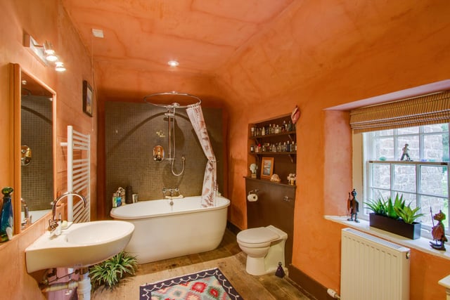 The bathroom is certainly not small, boasting a stylish free-standing bath with a shower over