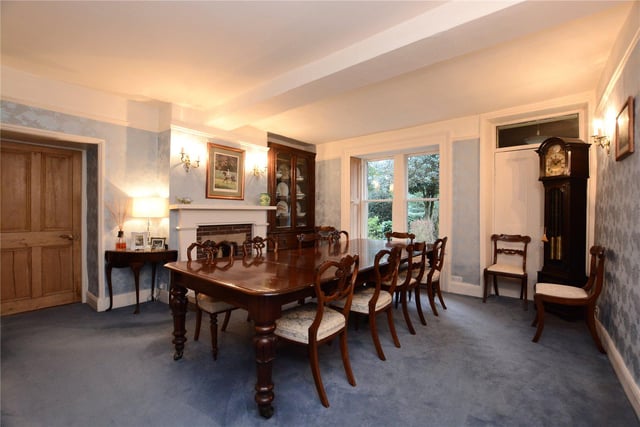 The formal dining room boasts the original front entrance door to the house, a beautiful feature fireplace with brick surround, and plenty of space for family meals or entertaining.
