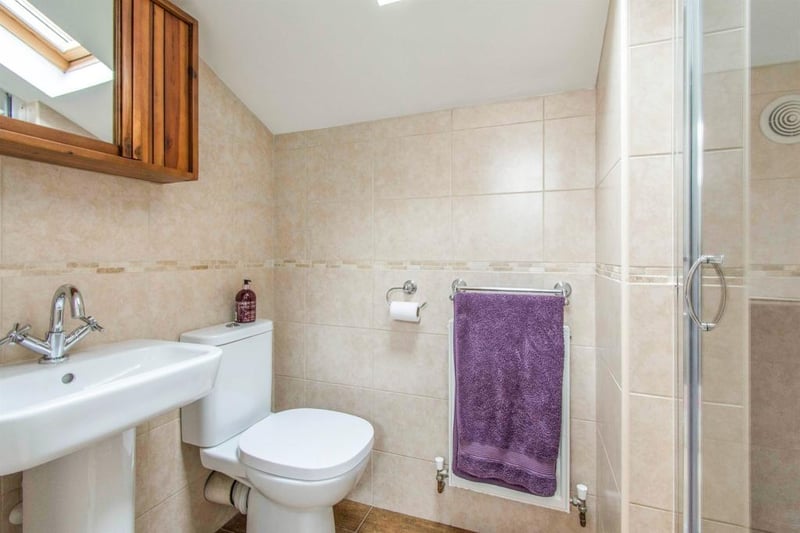 En Suite - Fitted with a WC, a wash hand basin and a shower cubicle with tiled surround. There is a front facing double glazed skylight window, spot lights to the ceiling, porcelain tiled flooring, an extractor fan and a central heating radiator.
