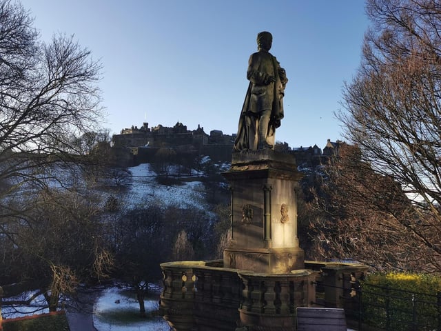 The statue of Scottish poet, Allan Ramsay, basks in some lovely winter sunshine on Princes Street, Edinburgh, with Edinburgh Castle sitting majestically in the background
