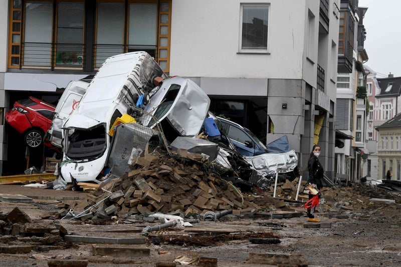 A woman stands next to cars and rubble piled up in a street after the floods caused major damage in Bad Neuenahr-Ahrweiler, western Germany, on July 16, 2021.