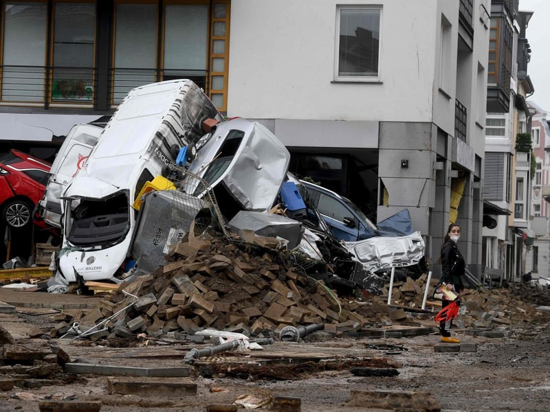 A woman stands next to cars and rubble piled up in a street after the floods caused major damage in Bad Neuenahr-Ahrweiler, western Germany, on July 16, 2021.