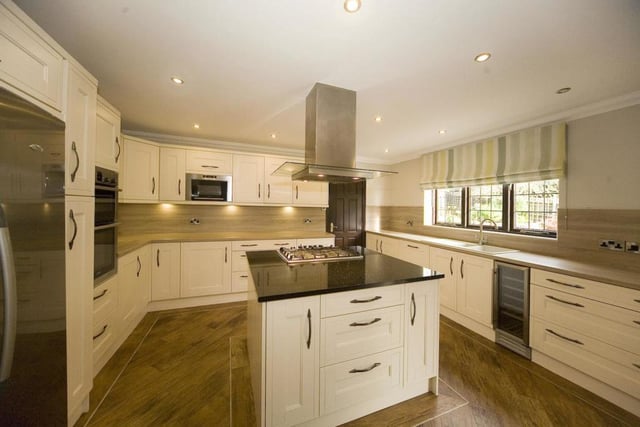 The kitchen is fitted with many appliances, including a wine cooler and an oven.