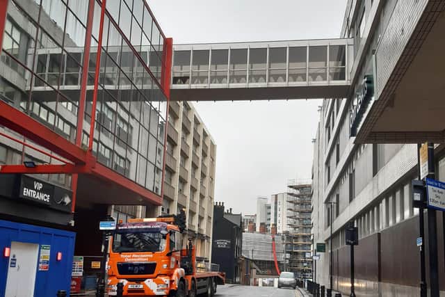 The John Lewis footbridge will be supported by crane while it is detached at both ends.